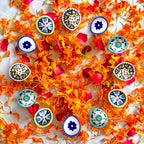 Close-up detail of a floral-patterned hand-painted blue pottery diya lamp.