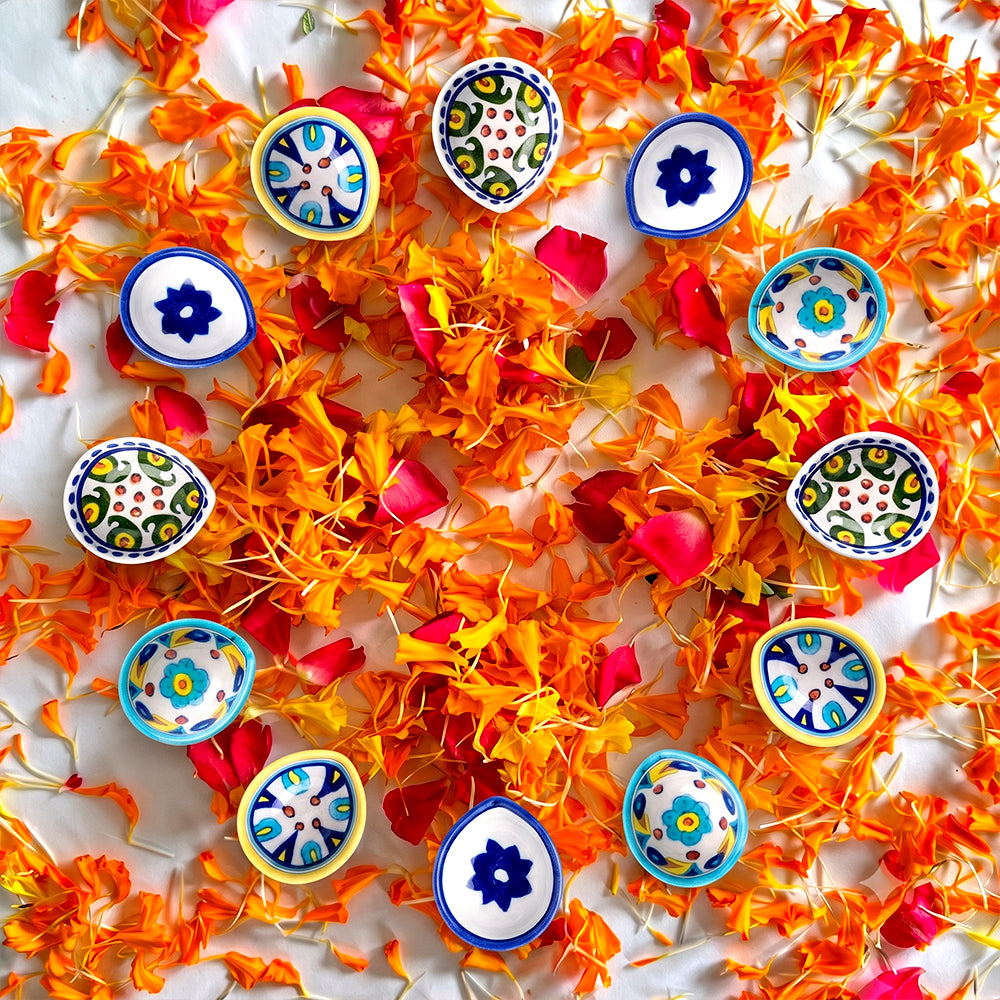 Close-up detail of a floral-patterned hand-painted blue pottery diya lamp.