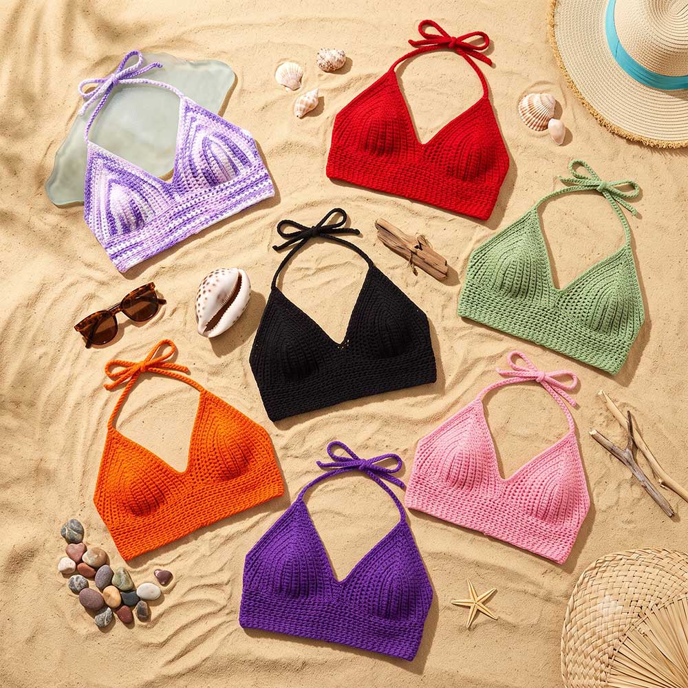 Collection of vibrant hand-crocheted halter bikini tops in various colors displayed on sand.