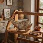 Decorative woven fish on a wooden chair with a rustic background
