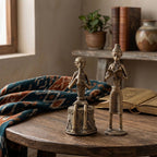 Two metallic figurines on a wooden table with a warm-toned background