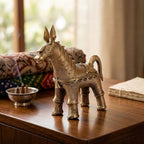 Bronze donkey figurine on a wooden surface with a blurred background