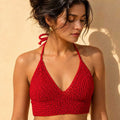 Flat lay of bright purple crochet bikini top.