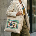 Person wearing a beige blazer with a tote bag featuring a colorful design.
