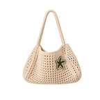 Close-up detail of the hand-crocheted cream textile and star embellishment on the tote bag.