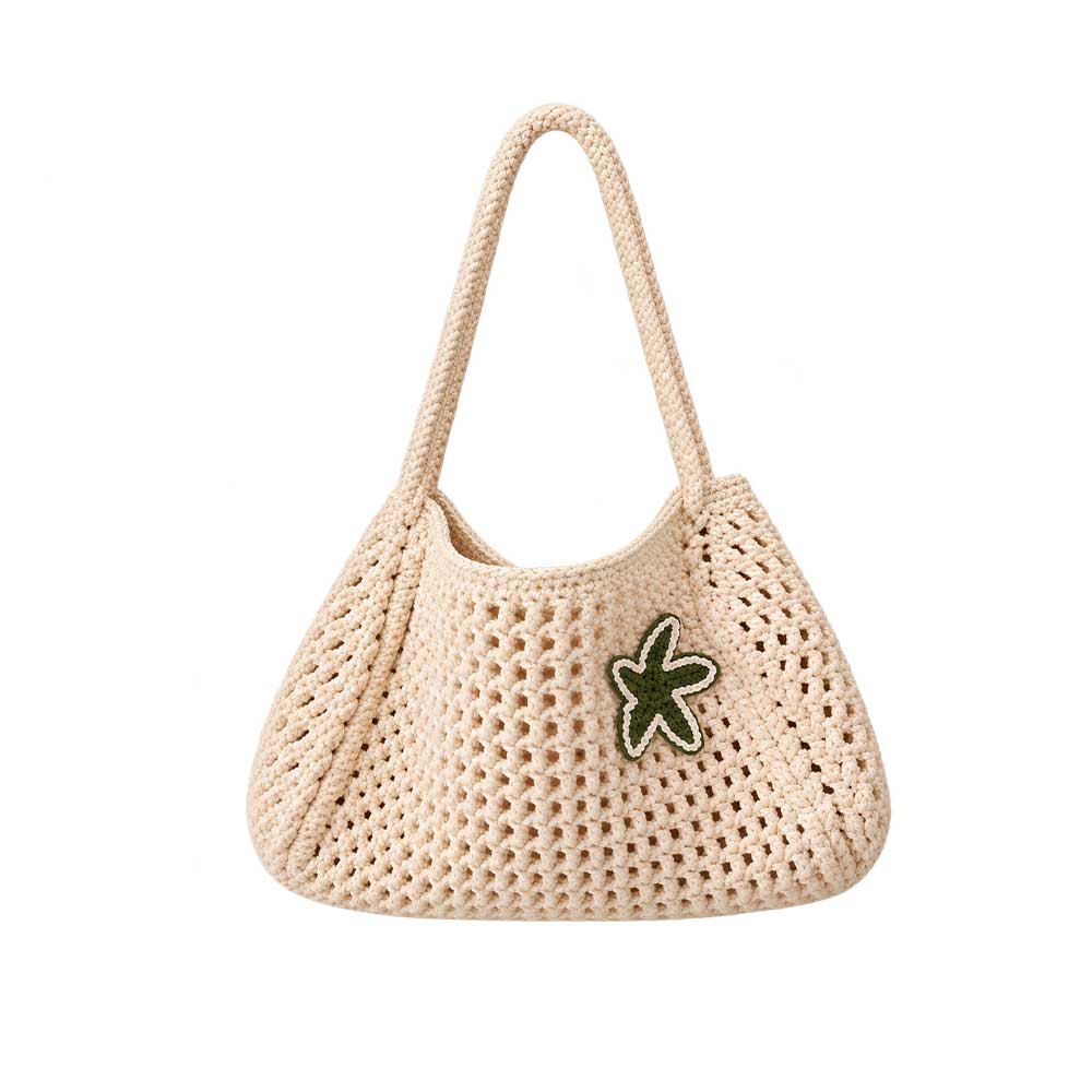 Close-up detail of the hand-crocheted cream textile and star embellishment on the tote bag.