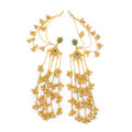 Pair of DI gold plated Bahubali statement earrings with green floral stone studs and multilayered ghungroo kan chains laid flat on white background