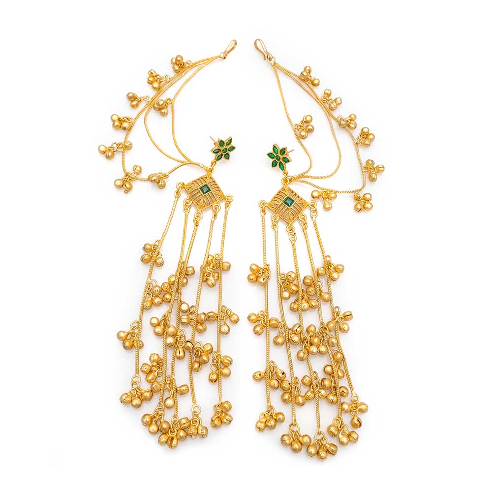 Pair of DI gold plated Bahubali statement earrings with green floral stone studs and multilayered ghungroo kan chains laid flat on white background