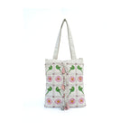 Tote bag with green lizard and flower pattern on a white background