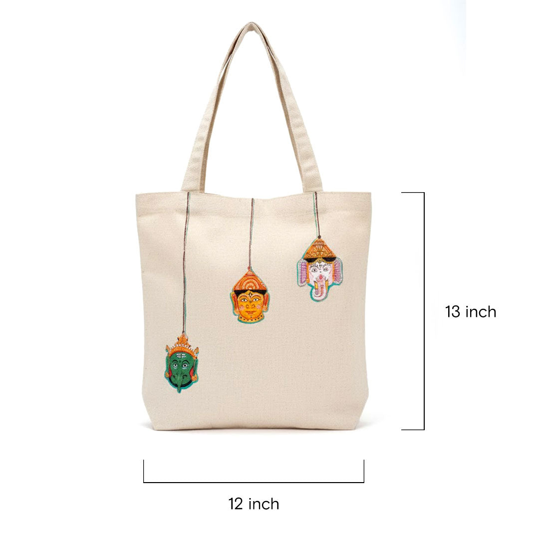 Beige tote bag with decorative elements and measurements on a white background