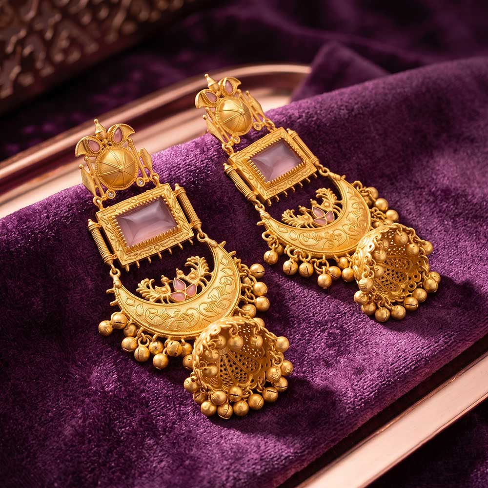 Macro detail shot of the pink stone and gold peacock engraving on the jhumka earrings