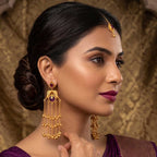 Close-up detail of the peacock motif and purple stone on the gold plated jhumka earring