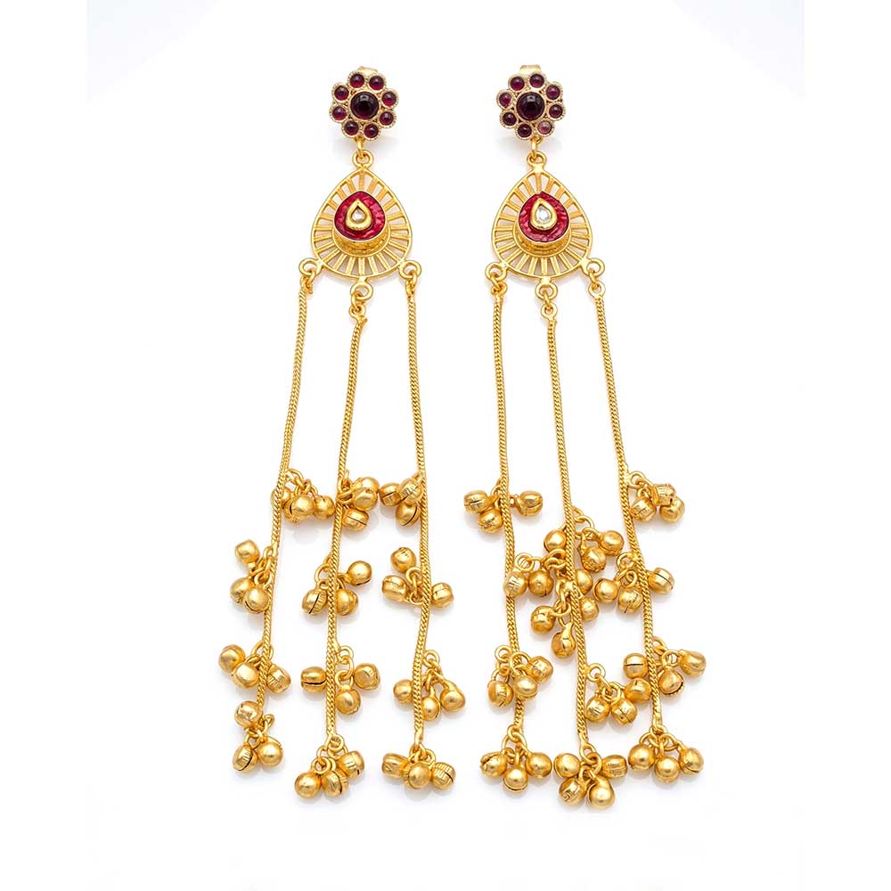 A pair of DI gold-plated traditional drop earrings with red stone centers and dangling ghungroo beads against a white background.