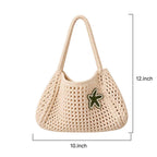 Front view of a hand-crocheted cream tote bag featuring a green embroidered star accent, measuring 10 by 12 inches.