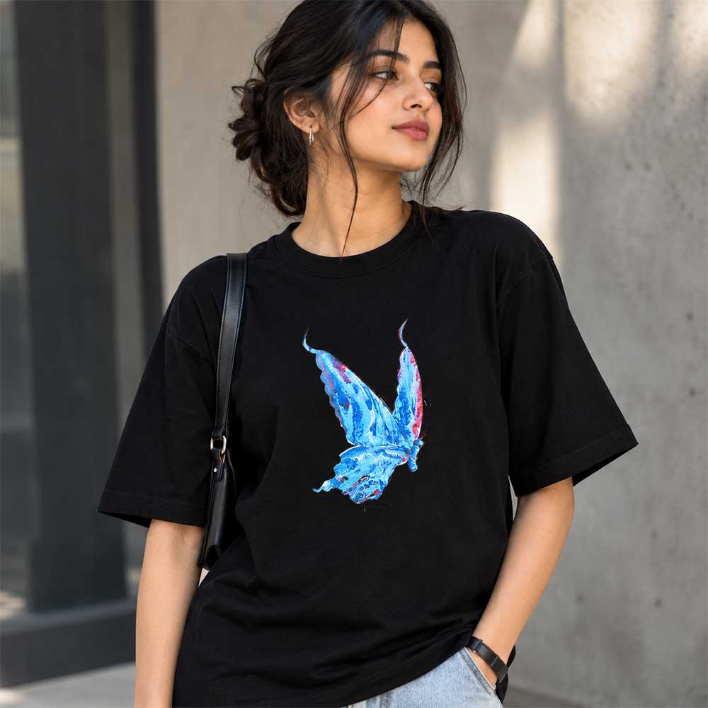 Close-up detail of the hand-painted vibrant blue butterfly artwork on pure black cotton fabric