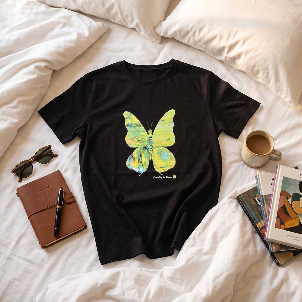 Full length view of the black hand-painted butterfly t-shirt on a clothes hanger against a neutral background.