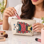 Angled perspective of hand-painted cotton cosmetic pouch styled on a vanity counter