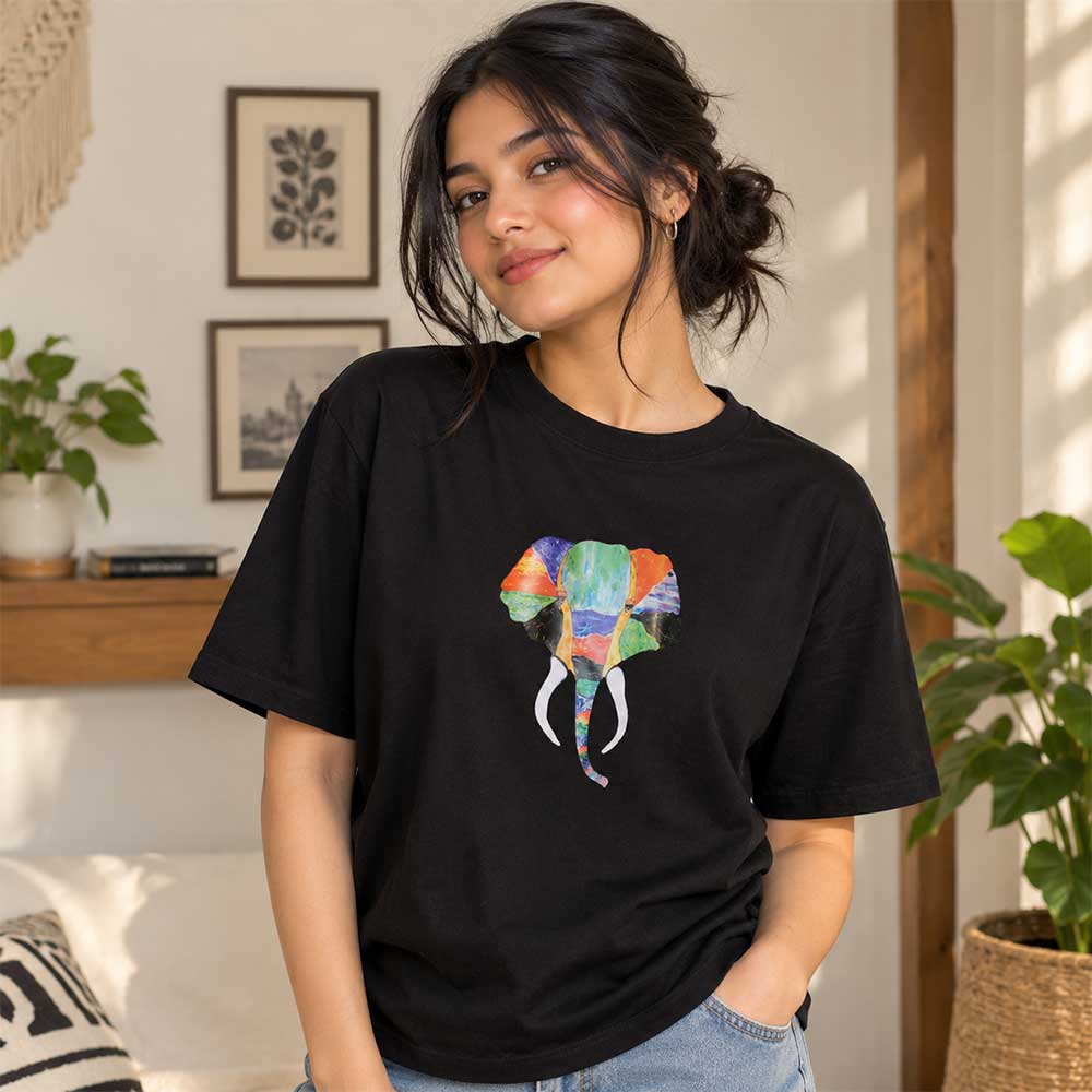 Close up detail of the multi-colored hand-painted elephant design on a black cotton t-shirt