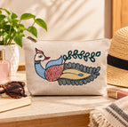 Angle view of artisan hand-painted peacock cotton zippered pouch showing depth and texture