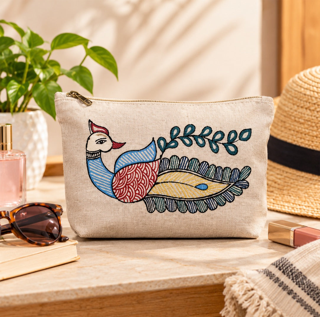 Angle view of artisan hand-painted peacock cotton zippered pouch showing depth and texture