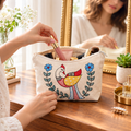 In-use lifestyle view of the hand-painted cotton pouch holding everyday cosmetics and accessories