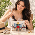 In-use lifestyle demonstration of hand-painted cotton pouch holding makeup and daily accessories