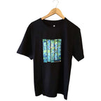 Front view of an artistic black pure cotton T-shirt with a hand-painted blue and green abstract graphic on a hanger.