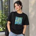 Close-up detail of the hand-painted abstract art on the black cotton T-shirt.
