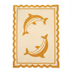 Full top-down view of a rectangular beige hand-tufted New Zealand wool area rug with two yellow dolphins and a yellow scalloped border.