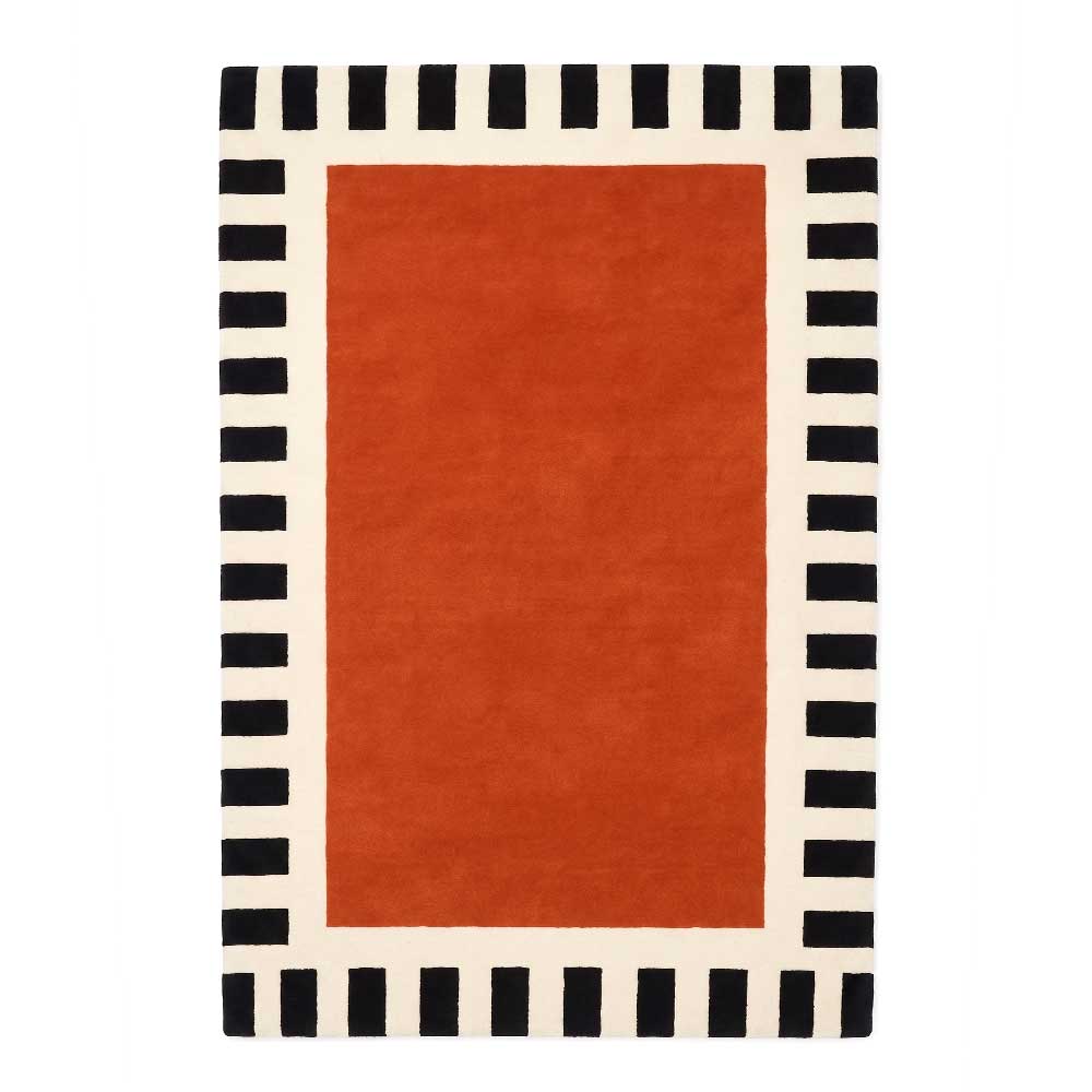 A luxurious hand-tufted New Zealand wool rug featuring a deep burnt-orange center and a black-and-cream striped border, viewed from a top-down flat perspective.