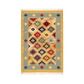 Front view of an artisanal hand-woven Mirzapur Kilim rug featuring a vibrant geometric tribal pattern and a sage green border.