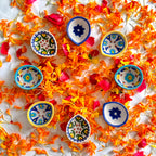 A close-up detail shot of a floral hand-painted blue pottery diya.