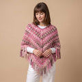 Model in studio wearing handmade pink and taupe crochet poncho over a white long-sleeve shirt