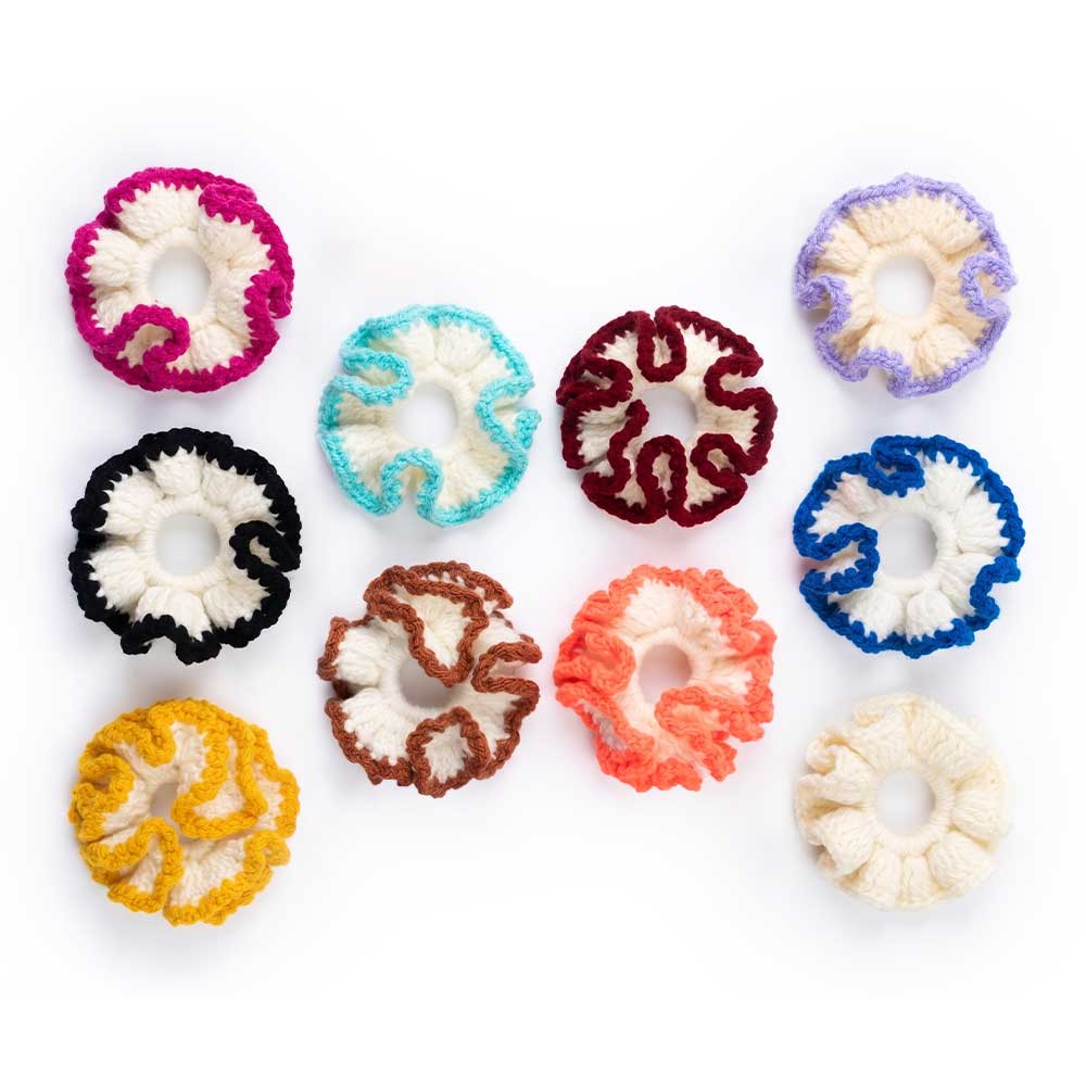 Assortment of handmade crochet ruffle hair scrunchies in various colorful contrast trim options on white background