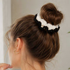 Model showing cream crochet hair scrunchie with black scalloped edge wrapped around an updo bun