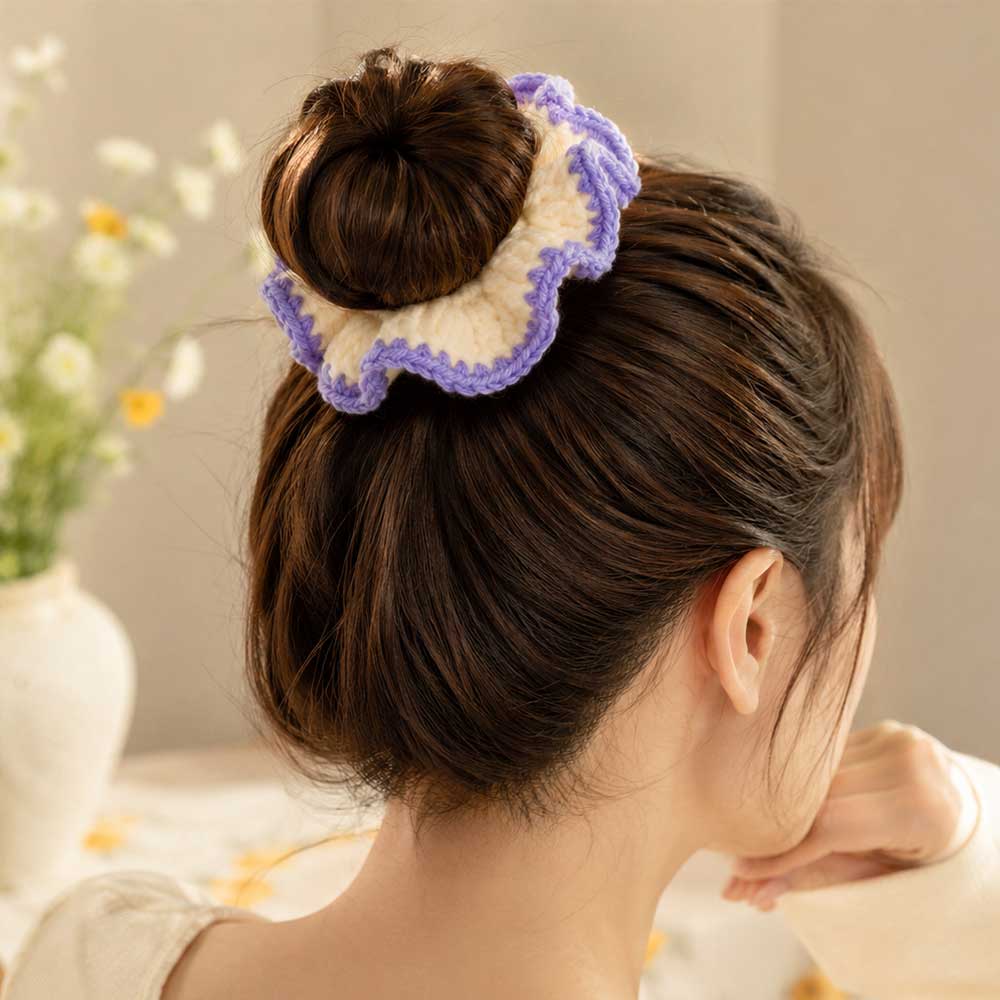 Model wearing cream and lavender crochet ruffle scrunchie styled around a high hair bun from behind