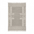 Top-down view of a rectangular Mirzapur handwoven rug featuring grey background and white bohemian geometric patterns with tasseled fringe.