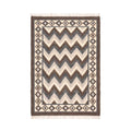 Handwoven Mirzapur wool area rug with charcoal and cream chevron pattern and tasseled fringe, overhead view.