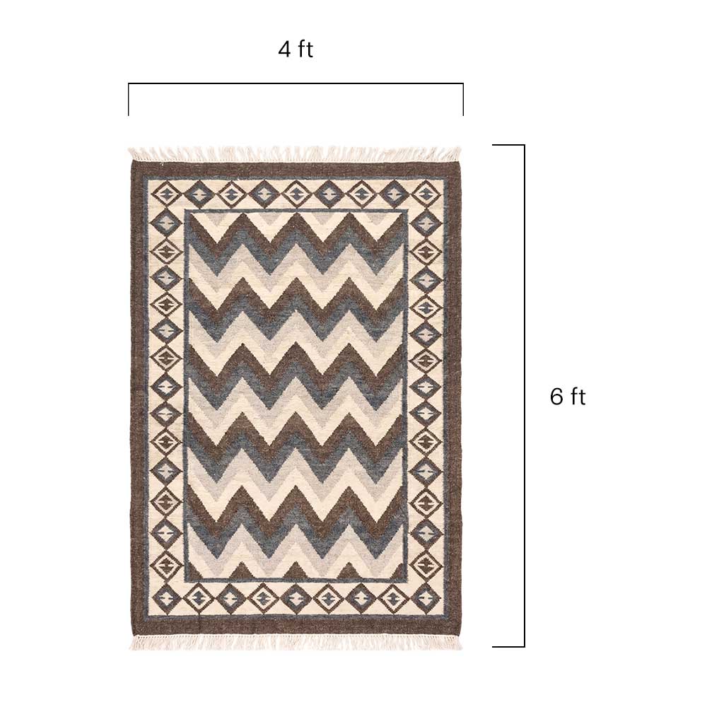 Close-up detail of the hand-knotted tassel fringe and woven texture of the Mirzapur chevron rug.