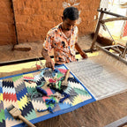 Artisans working with a colorful fabric pattern 