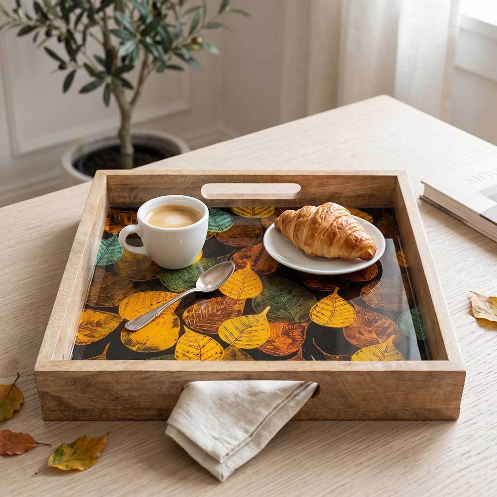 Close-up detail of the smooth enamel leaf print and natural grain of the mango wood serving tray.