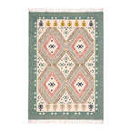 Full top flat-lay view of the Mirzapur handcrafted geometric flatweave area rug featuring sage green border, pink diamond patterns, and fringe tassels