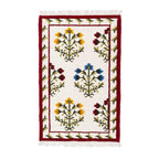 Mirzapur hand-tufted wool rug featuring a cream background with yellow, blue, and red botanical floral motifs and a red border, top-down view