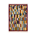 Flat-lay view of an authentic hand-woven Mirzapur geometric diamond rug with red border and tassels.