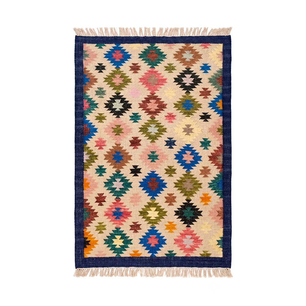 Full overhead view of a colorful hand-woven Mirzapur area rug with geometric diamond patterns and fringe edges.