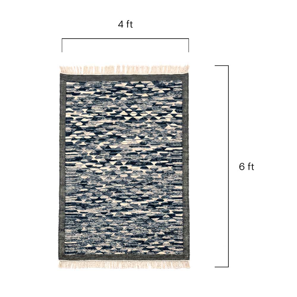 Close-up detail of the handwoven geometric texture and wool material of the Mirzapur area rug.