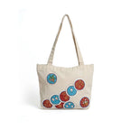 Beige tote bag with colorful circular patterns on a white background