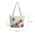 Beige tote bag with colorful circular patterns on a white background