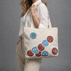 Person holding a beige tote bag with colorful circular designs on a gray background