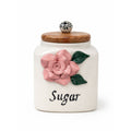 Decorative ceramic sugar jar with pink floral design and wooden lid on a white background